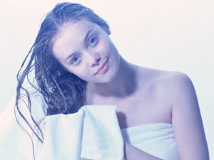 シャンプーの後で髪を乾かしている女性